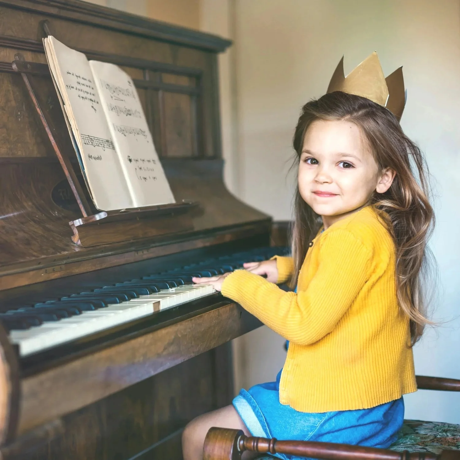 Young child smiling at the piano during a Studio Joy lesson