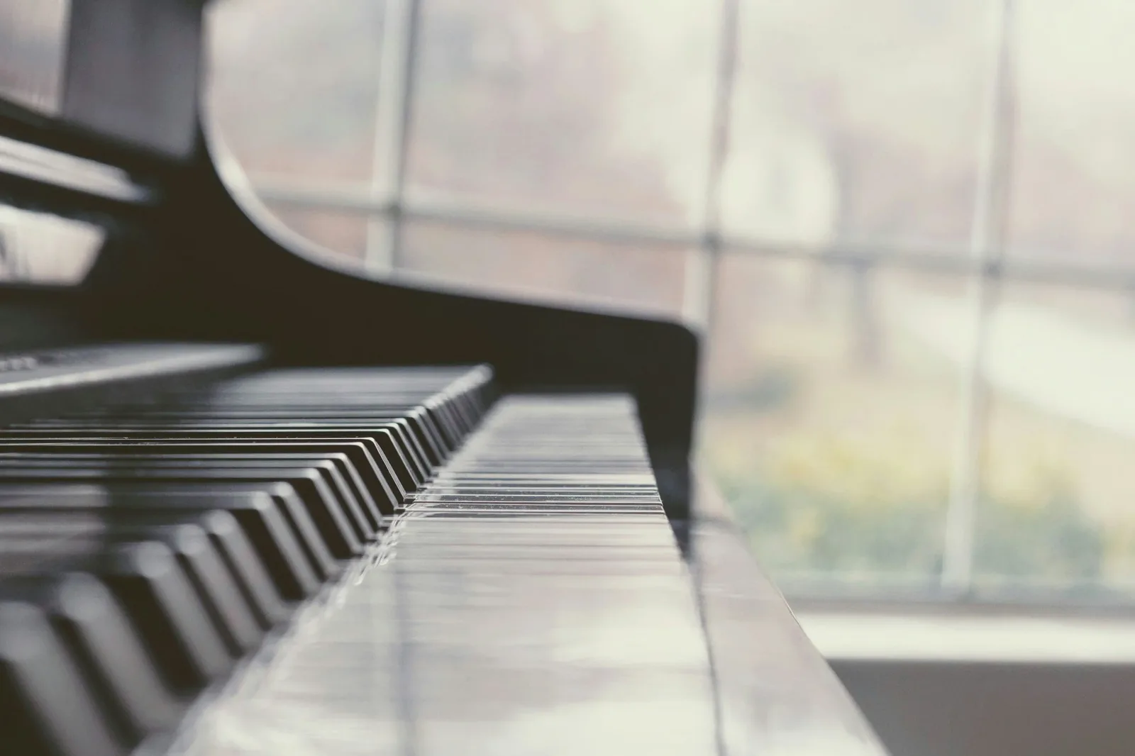 Piano keyboard beside a bright window